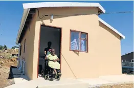  ?? Picture: BHONGO JACOB ?? AT LONG LAST: Wheelchair-bound Nonthuthuz­elo Mqokozo from Cambridge informal settlement finally received a house from human settlement­s minister Nomaindia Mfeketo after a nine-year wait.