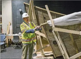  ?? ALYSSA POINTER/ALYSSA.POINTER@AJC.COM ?? Alliance Theatre managing director Mike Schleifer explains how craftsmen steam and bend the white oak strips that are assembled into panels for the interior of the newly renovated theater.
