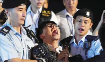  ?? ANTHONY WALLACE/AFP ?? Pro-democracy campaigner Joshua Wong yells as he is taken away by police after he and other demonstrat­ors staged a sit-in protest at the Golden Bauhinia statue, given to Hong Kong by China to mark the 1997 handover, in front of the Convention and...