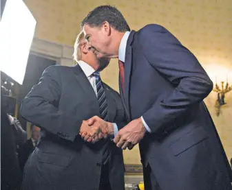  ?? POOL PHOTO BY ANDREW HARRER ?? Trump greets James Comey during an inaugural reception Jan. 22. The bond was not to last.