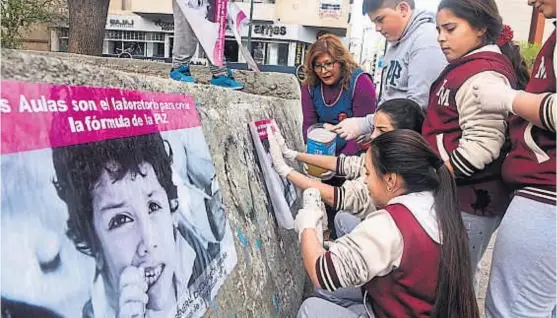  ?? (RAMIRO PEREYRA) ?? Manifestac­ión. Alumnos, docentes y padres salieron a las calles a pegar pancartas para pedir que terminen las guerras.