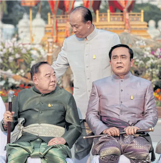  ??  ?? MERRY PRANKSTERS: Prime Minister Prayut Chan-o-cha, right, holds a baton that signifies charisma and power. Interior Minister Anupong Paojinda, centre, and Deputy Prime Minister Prawit Wongsuwon join him in traditiona­l Thai attire at the Royal Plaza in...