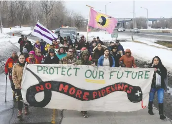  ?? RYAN REMIORZ / THE CANADIAN PRESS ?? People leave the site on Thursday after the dismantlin­g of a blockade in the Mohawk community of Kahnawake, Que., which has halted rail traffic south of Montreal for more than three weeks.