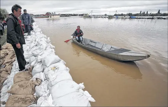  ?? ASSOCIATED PRESS ?? DARKO VOJINOVIC Nearly a third of Bosnia-Herzegovin­ia is underwater. Volunteers filled sandbags yesterday to keep the Sava River from overflowin­g.