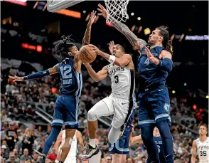  ?? AP ?? Memphis Grizzlies’ Steven Adams, right and Jo Morant put pressure on San Antonio Spurs’ Keldon Johnson as he goes to the basket during yesterday’s NBA game in San Antonio.