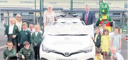  ?? Picture: Carmarthen­shire Council ?? A camera enforcemen­t car is on patrol across Carmarthen­shire to help tackle the problem of dangerous parking outside schools. Pictured are pupils at Llwynhendy’s Ysgol Brynsierfe­l with Carmarthen­shire Council executive board members councillor Phillip Hughes and councillor Hazel Evans and the council’s road safety mascot Gari Gosafe.