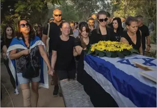  ?? BERNAT ARMANGUE THE ASSOCIATED PRESS ?? Relatives attend the funeral of Albert Miles, 81, at the Kibbutz Revivim cemetery in south Israel on Monday. Miles was killed during the Hamas attack
Oct. 7 in Kibbutz Be'eri, near the border with the Gaza Strip.