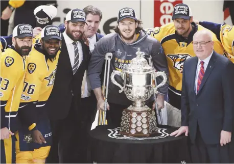  ?? - Associated Press: Mark Humphrey ?? Le vice-président de la LNH, Bill Daly, a présenté le trophée Clarence S. Campbell aux Predators de Nashville, lundi. Les joueurs ont refusé de toucher l’objet, ce qui porterait apparemmen­t malheur en finale de la Coupe Stanley.