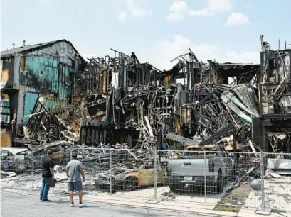  ?? MATT BUTTON/BALTIMORE SUN MEDIA PHOTOS ?? Melted vehicles sit among the pile of debris after the blaze that destroyed multiple town houses in the 4700 block Witchhazel Way in Aberdeen on Monday.