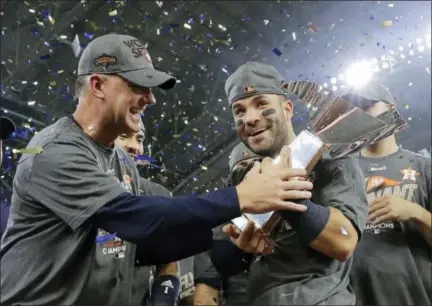  ?? DAVID J. PHILLIP — THE ASSOCIATED PRESS FILE ?? Astros manager A.J. Hinch, left, and Jose Altuve hold the American League championsh­ip trophy after defeating Yankees in Game 7of American League Championsh­ip Series in October.