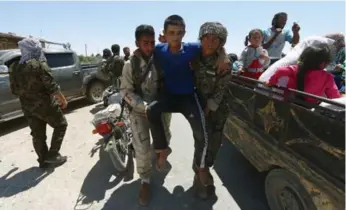  ?? RODI SAID/REUTERS ?? Syria Democratic Forces fighters help an injured civilian as residents evacuate Manbij city’s southern districts.