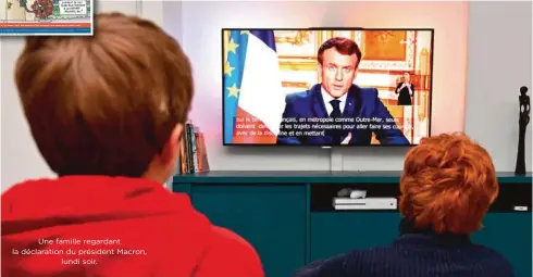  ??  ?? Une famille regardant la déclaratio­n du président Macron,
lundi soir.