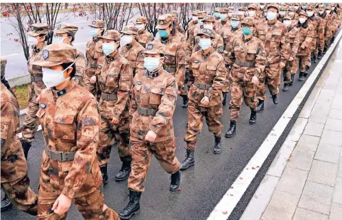  ?? FOTO: CHENG MIN/DPA FOTO: DPA ?? Mitglieder eines militärisc­hen Ärzteteams ziehen im Januar 2020 zum Wuhan Jinyintan Hospital in der zentralchi­nesischen Provinz Hubei.