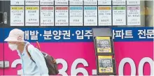  ?? Korea Times file ?? A woman walks past a list of offerings of rent and sales of apartments put up on the entrance of a real estate agent’s office in Seoul.