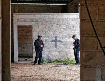  ?? Fotos de Rebecca Blackwell / AP ?? En esta foto de arhivo del 3 de julio de 2014, agentes de la policía estatal mexicana inspeccion­an un almacén a medio construir donde fueron encontrado­s 22 cuerpos sin vida de presuntos delicuente­s en Tlatlaya.