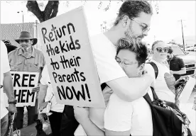  ?? DAVID J. PHILLIP
THE ASSOCIATED PRESS ?? Diana Jung Kim, right, and Homer Carroll, both from Houston, hug during a protest outside the U.S. Border Patrol Central Processing Center Monday, in McAllen, Texas.