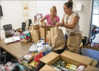  ?? PHOTOS BY RICARDO B. BRAZZIELL / AMERICAN-STATESMAN ?? Natalie Kifer (left) and Krista Harmon pick up bags of items Monday donated to Hurricane Harvey victims at the Circle C Community Center in South Austin. Kifer said she is rallying friends to send supplies to the Texas coastal cities hard-hit by the...