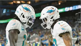  ?? LON HORWEDEL/AP ?? Dolphins receiver Jaylen Waddle, right, greets receiver Tyreek Hill after catching a 5-yard pass for a touchdown against the Lions on Oct. 30 in Detroit.