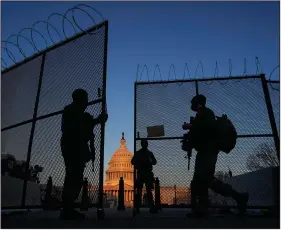 ?? (AP/Carolyn Kaster) ?? National Guard soldiers open a gate of the razor wire-topped perimeter fence around the Capitol last week to allow a comrade in.