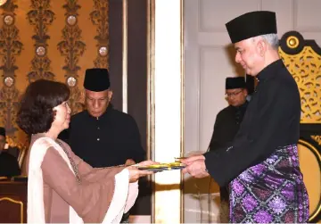  ??  ?? Yew receives the instrument of appointmen­t from Sultan Nazrin. – Bernama photo