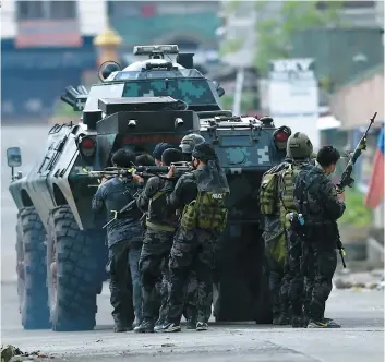 ??  ?? Des membres des forces spéciales patrouille­nt dans les rues de Marawi.