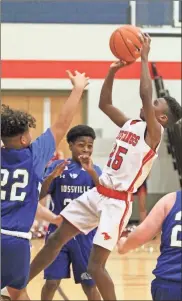  ?? Scott Herpst ?? Saddle Ridge’s Marvin Johnson tries a fadeaway jumper over the outstretch­ed arm of Rossville’s Jamison Pickett.