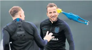  ?? ADRIAN DENNIS/AFP/GETTY IMAGES ?? Harry Kane (right) looks on as defender Phil Jones tries to catch a rubber chicken as England stays loose during a training session Tuesday ahead of today’s semifinal against Croatia.