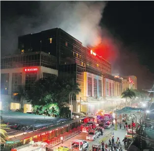  ?? — THE ASSOCIATED PRESS ?? Smoke rises from the Resorts World Manila complex in Manila, Philippine­s early Friday, after a man went into the casino with a gun and stole chips, then lit multiple blazes. He was later found dead.