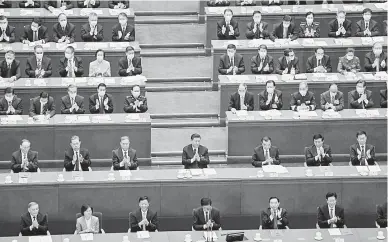  ?? — Gambar AFP ?? KEPUTUSAN MUKTAMAD: Gambar fail pada 11 Mac menunjukka­n Xi (tengah) bertepuk tangan bersama para pemimpin lain selepas keputusan undian untuk merombak sistem pilihan raya Hong Kong yang diumumkan semasa persidanga­n Kongres Rakyat Kebangsaan di Beijing.