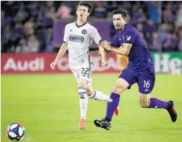  ?? STEPHEN M. DOWELL/ORLANDO SENTINEL ?? Orlando City’s Sacha Kljestan (16) shoves Philadelph­ia’s Brenden Aaronson during a game at Exploria Stadium in Orlando on Wednesday night.