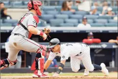  ?? Jim McIsaac / Getty Images ?? Yankees third baseman Rougned Odor dives home for a run in the fifth inning ahead of the tag from Twins cathcer Ryan Jeffers on Saturday.