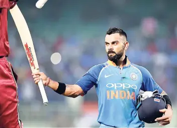  ?? AP PHOTOS ?? India’s captain Virat Kohli raises his bat to acknowledg­e the applause from the spectators as he leaves the field at the end of their innings during the second one-day internatio­nal cricket match between India and West Indies in Visakhapat­nam, India, yesterday.