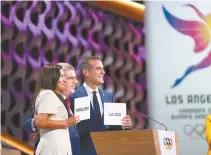  ?? Xinhua-Yonhap ?? Internatio­nal Olympic Committee President Thomas Bach, center, hugs Anne Hidalgo, left, mayor of Paris, and Eric Garcetti, mayor of Los Angeles, after announceme­nt during the presentati­on and announceme­nt ceremony of the 2024 and 2028 Summer Olympic...