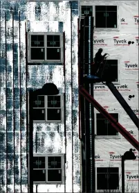  ?? Photo by Mark Stockwell ?? A constructi­on worker installs exterior insulation panels on the downtown Renaissanc­e South building in late December.