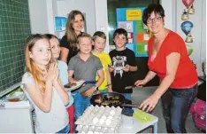  ?? Foto: Anja Ringel ?? Bäuerin Andrea Mayr (rechts) brachte den Kindern bei, aus was ein Ei besteht. Als Belohnung für die gute Mitarbeit gab es Spiegelei mit Brot.