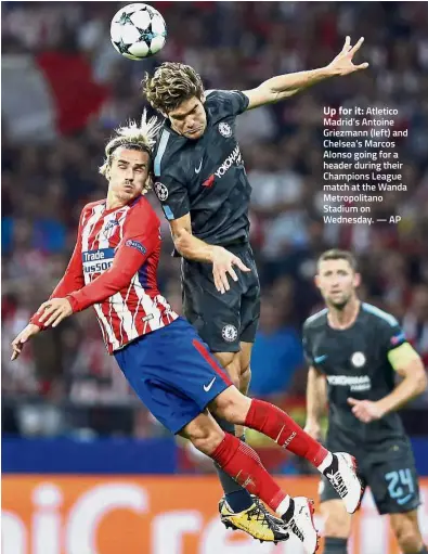  ?? — AP ?? Up for it: Atletico Madrid’s Antoine Griezmann (left) and Chelsea’s Marcos Alonso going for a header during their Champions League match at the Wanda Metropolit­ano Stadium on Wednesday.