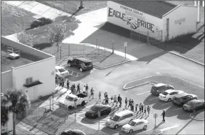  ?? Mike Stocker/AP ?? Evacuate: In this file photo, students are evacuated by police from Marjory Stoneman Douglas High School in Parkland, Fla., after a shooter opened fire on the campus. A large Wall Street money manager wants to engage with major weapons manufactur­ers...