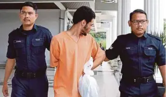  ?? PIC BY AHMAD IRHAM MOHD NOOR ?? Libyan student Ahmed Abdullah Ali being led out of the court complex in Sepang yesterday.