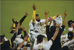  ?? GREGORY BULL — THE ASSOCIATED PRESS ?? San Diego Padres shortstop Fernando Tatis Jr., center, celebrates with teammates Friday after the Padres defeated the St. Louis Cardinals in Game 3 of a National League wild-card series.