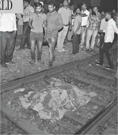  ?? PRABHJOT GILL / THE ASSOCIATED PRESS ?? A cloth covers the body of a victim on a railway track in Amritsar, India, on Friday, after a speeding train plowed through a crowd watching fireworks during a religious festival killing at least 50 people.