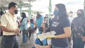  ?? — Photo from Ukas Miri ?? Lee (left) talks with a parent during his visit to inspect the PICK programme for 12 to 15 years old at PPV Eastwood Valley Hall yesterday.