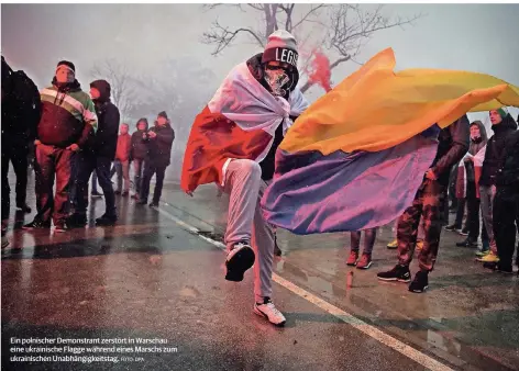  ?? FOTO: DPA ?? Ein polnischer Demonstran­t zerstört in Warschau eine ukrainisch­e Flagge während eines Marschs zum ukrainisch­en Unabhängig­keitstag.