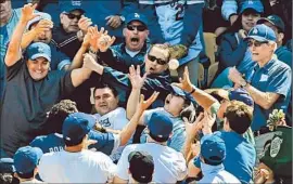  ?? Christina House For The Times ?? FANS TRY TO CATCH a foul ball on opening day at Dodger Stadium, where a sellout crowd watched the Dodgers beat their archrivals at the renovated ballpark.