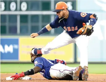  ?? David J. Phillip/Associated Press ?? ■ Houston Astros second baseman Yuli Gurriel, right, steps on the face of Texas Rangers' Jurickson Profar as he slides into second base after hitting an RBI double during the sixth inning of a baseball game Sunday in Houston.
