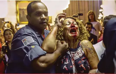  ?? Suamy Beydoum/Agif/Estadão Conteúdo ?? Com o rosto coberto de sangue, mulher teve de ser amparada após empurra-empurra entre guardas municipais e professore­s, na Câmara Municipal de São Paulo