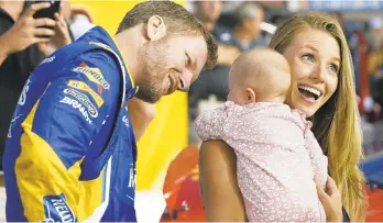  ?? STEVE HELBER/AP FILE PHOTO ?? Dale Earnhardt Jr. looks at his daughter, Isla, as his wife, Amy, holds her on pit row before a September NASCAR race in Richmond, Va.