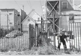  ?? ARMANDO L. SANCHEZ/CHICAGO TRIBUNE ?? An evidence technician works the scene where a 14-year-old boy was fatally shot in the 1100 block of South Karlov Avenue in the Lawndale neighborho­od on June 10.