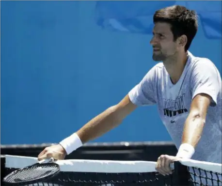  ?? MARK SCHIEFELBE­IN — THE ASSOCIATED PRESS ?? Serbia’s Novak Djokovic rests on the net during a practice session at the Australian Open tennis championsh­ips in Melbourne, Australia, Sunday.