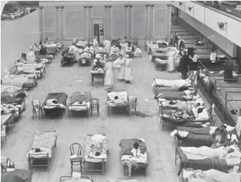  ?? EDWARD A. “DOC” ROGERS/LIBRARY OF CONGRESS ?? Volunteer nurses from the American Red Cross tend to influenza patients in 1918, in the Oakland Municipal Auditorium, used as a temporary hospital. As scientists mark the 100th anniversar­y of the Spanish influenza pandemic, labs around the country are...