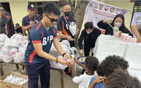  ?? ?? Fire Senior Inspector Joshua Ayson, acting fire marshal of Mabalacat City, leads the feeding program at Sitio Calapi as part of the celebratio­ns for Fire Prevention Month. The fire department also held a Fire Olympics, which was won by Barangay Dau.